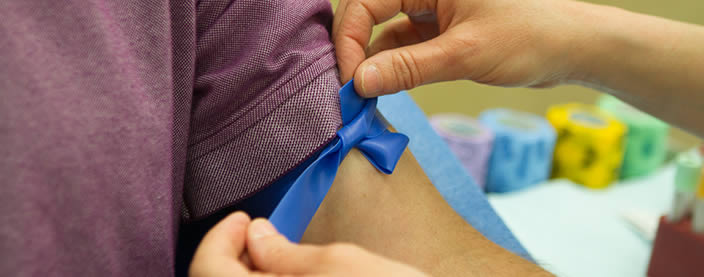nurse tying a rubberband around patient's arm